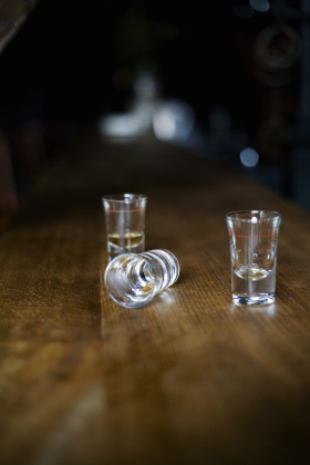 Three empty shot glasses on a bar