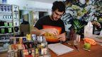 Juan Manuel, owner of the first shop dedicated to cannabis merchandising in Montevideo, rolls a cannabis cigarette at his shop counter