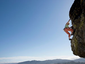 Low angle view of woman rock climbing. John Lund/Matt Holmes