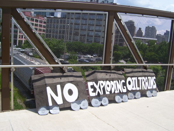 "No Exploding Oil Trains" banner displayed as shale oil train passes by the morning of  Philadelphia oil trains action, July 9 2014. Photo: Ann Dixon