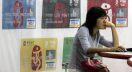 FILE -  In this Sept. 1, 2005 file photo, a Chinese woman uses a computer with designs of credit cards issued by the Bank of China in the background  during a financial exposition in Beijing, China. China's Cabinet said on Thursday, Oct. 30, 2014 it will ease restrictions on credit cards in a move that might give Visa, Mastercard and other foreign competitors greater access to the Chinese market.