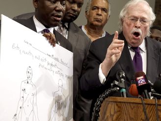 Dr. Michael Baden, right, speaks as Brown family attorney Benjamin Crump, left, holds a diagram produced during a second autopsy done on 18-year-old Michael Brown Monday, Aug. 18, 2014, in St. Louis County, Mo.