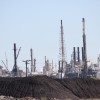 Piles of petroleum coke sit uncovered on the ship canal in Corpus Christi.