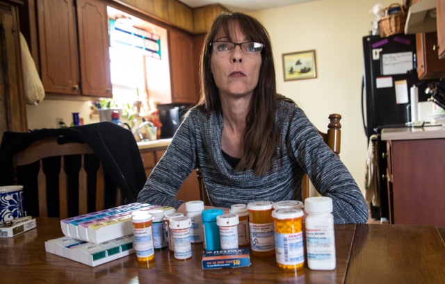 Barbara Brown with medications she takes for health problems developed after fracking intensified near her Reno, Texas home. She lives less than a mile from a fracking site and a wastewater disposal site. Her home has been damaged by an earthquake swarm that started rattling the ground in November, 2013, shortly after the disposal plant began operation. ©2014 Julie Dermansky