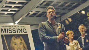 Ben Affleck stands next to Rosamund Pike’s picture as he asks for the public’s help in Gone Girl.