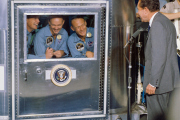 Apollo 11 astronauts Neil Armstrong, Michael Collins and Buzz Aldrin, in NASA's mobile quarantine trailer, meet President Nixon aboard the USS Hornet after splashdown, July 1969.