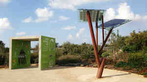 A small solar-powered tree, invented by Israeli energy entrepreneur Michael Lasry, stands at the edge of natural greenery.