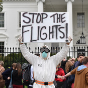 A protester outside the White House demands a halt to all flights to the United States from West Africa.