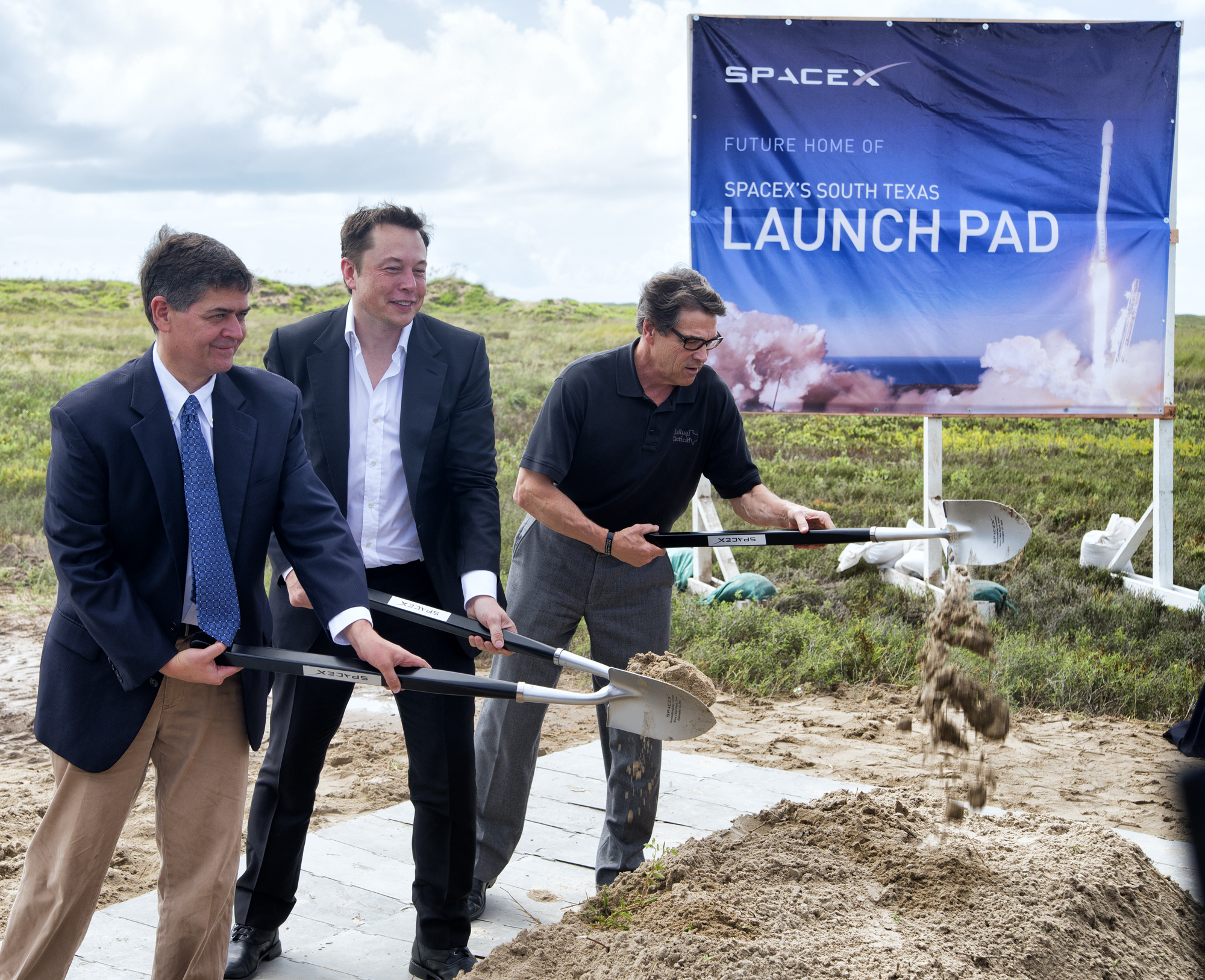 U.S. Rep. Filemon Vela, left, SpaceX founder and CEO Elon Musk, center, and Texas Gov. Rick Perry turn the first shovel-full of sand at the groundbreaking ceremony for the SpaceX launch pad at Boca Chica Beach, Monday, Sept. 22, 2014. (AP Photo/Valley Morning Star, David Pike)