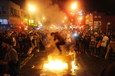 People gather around a fire on Mission St. after the Giants defeated the Kansas City Royals in Game 7 of the World Series. James Tensuan/KQED