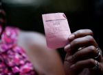 Kimberly Price, 49, who has been through the Harris County Jail prostitute intervention program called We've Been There Done, holds her voting access code number after she joined about 15 former prostitutes from the program voted at an early voting location downtown Wednesday, Oct. 29, 2014, in Houston. "I'm an ex-con; I have felonies; I've had the hard part of life," Price said who voted for the first time. "And today it made a difference that my voice does me something."