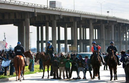 Occupy Houston protestors stand in protest in the exit ramp of Loop 610 at the Port of Houston Authority Monday, Dec. 12, 2011, in Houston. The event, Occupy The Port, was part of a nationwide movement targeting the nation's ports. Around 20 members were arrested according to the Houston Police Department. (Cody Duty / Houston Chronicle) Photo: Cody Duty / © 2011 Houston Chronicle