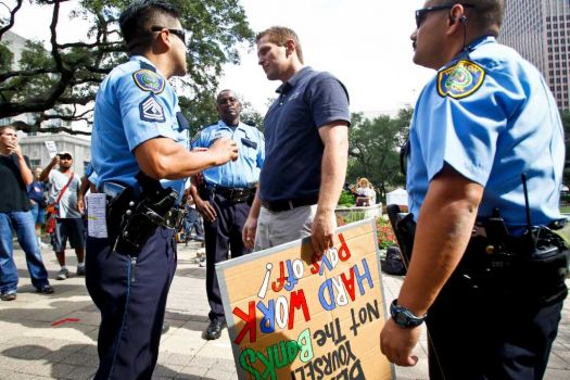 Justin Conry (right) an anti-protestor is confronted by HPD officers during a gathering of protestors with the Occupy Houston movement, an outgrowth of the Occupy Wall Street protests in New York, gather at City Hall in downtown Houston to denounce what they describe as social and economic equality and corporate greed, Thursday, Oct. 6, 2011, in Houston. Photo: Michael Paulsen, Houston Chronicle / © 2011 Houston Chronicle