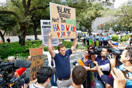 Justin Conry (center) an anti-protestor is hounded by members of the media as protestors with the Occupy Houston movement, an outgrowth of the Occupy Wall Street protests in New York, gather at City Hall in downtown Houston to denounce what they describe as social and economic equality and corporate greed, Thursday, Oct. 6, 2011, in Houston. Photo: Michael Paulsen, Houston Chronicle / © 2011 Houston Chronicle