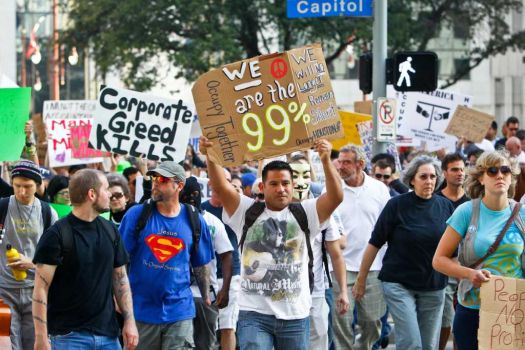 David Cervantes (center) holds a sign as he and other protestors with the Occupy Houston movement, an outgrowth of the Occupy Wall Street protests in New York, march to City Hall as they gathered in downtown Houston to denounce what they describe as social and economic equality and corporate greed, Thursday, Oct. 6, 2011, in Houston. Photo: Michael Paulsen, Houston Chronicle / © 2011 Houston Chronicle