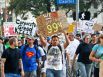 David Cervantes holds a sign as he and other protestors with the Occupy Houston movement march to City Hall.