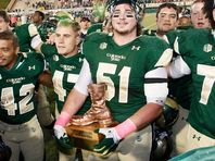 Oct 25, 2014; Fort Collins, CO, USA; Colorado State Rams offensive lineman Ty Sambrailo (51) holds the Bronze Boot with teammates following the game against the Wyoming Cowboys at Hughes Stadium. The Rams defeated the Cowboys 45-31.