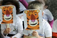  Youngsters hold tiger masks during a reading of “Mr. Tiger Goes Wild” by Peter Brown at the Hyundai Club West Lounge of Heinz Field. The event was an attempt to set a record for the world's largest vocabulary lesson.