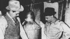 George W. Cox (left) and C.W. Berry, agents of the state liquor control board, seize a 35-gallon still in the kitchen of a home in the 400 block of South Hamilton Street, 30 blocks from town. The agents found 150 gallons of mash and two gallons of whiskey, and arrested Gregorio Alcasio, 32, in connection with the seizure. Agents said Alcasio ran the still because he could find no other work. Published in the San Antonio Light Feb. 5, 1938.
