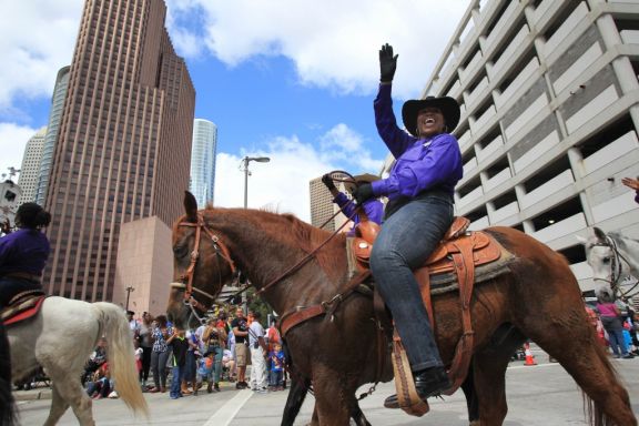 Members of the Prairie View Trail Ride wave to the crowd during the 76th Annual Houston Rodeo Parade gets started on Saturday, March 1, 2014, in Houston. ( Mayra Beltran / Houston Chronicle )