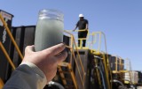 A jar holding wastewater from hydraulic fracturing is held up to the light at a recycling site in Midland, Texas. (AP Photo/Pat Sullivan)