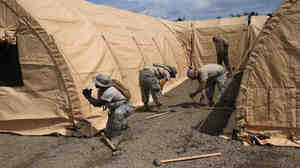 Air Force personnel put up tents to house a 25-bed, U.S.-built hospital for Liberian health workers sick with Ebola in Monrovia, Liberia's capital. The hospital is scheduled to open this weekend.