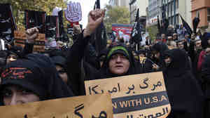 Iranian women chant during a demonstration in front of the former U.S. Embassy in Tehran, marking the 1979 takeover just days ahead of a key meeting between the two nations' top diplomats over Iran's nuclear program.