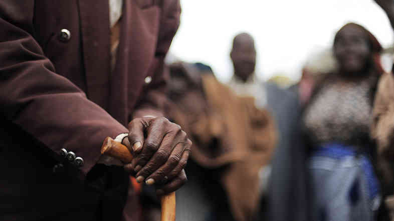 A Kenyan senior citizen leans on his cane. As people age in parts of Africa, they report declining levels of satisfaction with their life.