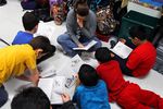 A reading assistant reads on the classroom floor with a small group of fourth graders at Wanke Elementary School in San Antonio on March 9, 2012.