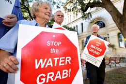 Lee County resident Hilde Sides protests the Vista Ridge Water Supply Project with other Lee and Bastrop County residents outside the San Antonio City Council public hearing on the project on Oct. 8.