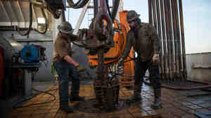 Workers drill for oil in the Bakken shale formation outside Watford City, N.D., an area experiencing an oil boom.