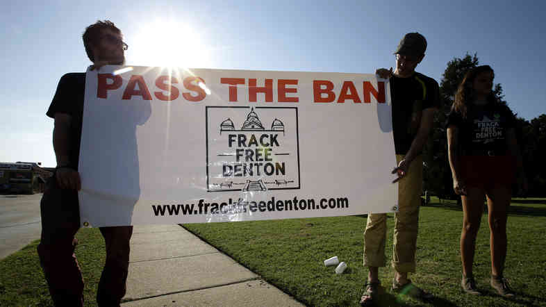 From left, Topher Jones, Edward Hartmann and Angie Holliday hold a campaign sign outside City Hall in Denton, Texas, on July 15, 2014. Voters in the college town approve a ban on fracking on Tuesday.