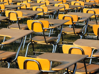 Empty school desks sit on a lawn. (credit: Alex Wong/Getty Images)