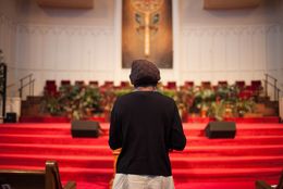 A woman, who asked not to be identified because she fears for her safety, stands near the pulpit at the end of service at First Baptist Church on Sunday, Sept. 14, 2014, in El Paso. The woman fled Boko Haram in Nigeria and is now seeking asylum.