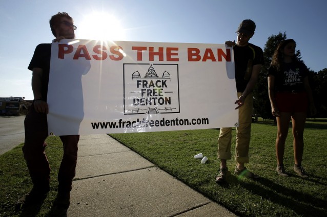  Topher Jones, of Denton, Texas, Edward Hartmann, of Dallas and Angie Holliday of Denton, Texas, hold a campaign sign outside city hall, in Denton, Texas in July, 2014.