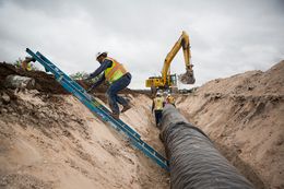 Water pipeline crew members prepare for the laying of the next section of the 60-mile-long chain running near Eden, Texas.