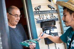 Chris Ornelas, a Texas Organizing Project employee, speaking with Armando Rodriguez while canvassing in San Antonio's west side on Sept. 4, 2014.