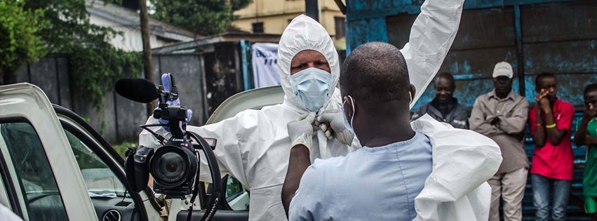 NPR photographer David Gilkey puts on protective gear before entering a hospital in Monrovia, Liberia, to document the removal of an Ebola victim. Photo by Tommy Trenchard for NPR.
