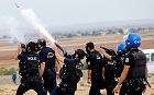 Turkish riot police fire tear gas to disperse pro-Kurdish protesters near the Turkish-Syrian border in the southeastern town of Suruc in Sanliurfa province