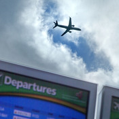 A plane takes off over a departure board at Hartsfield-Jackson Airport in Atlanta last November. Airlines say they expect an uptick in Thanksgiving travel this year.