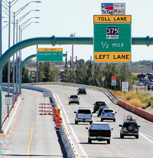 Vehicles travel on the Cesar Chavez Border Highway Thursday. Signs for the new toll lanes have begun to go up.