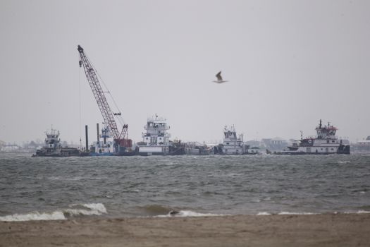 Emergency crews work along a barge that was struck by a ship shown near the Texas City Dike Sunday, March 23, 2014. (Melissa Phillip / Houston Chronicle)