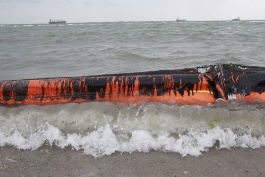 An oil covered boom is show on the beach area along Boddeker Rd. on the east end of Galveston near the ship channel Sunday, March 23, 2014 in Galveston. Photo: Melissa Phillip