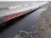 An oil covered boom is washed ashore on the beach area along Boddeker Rd. on the east end of Galveston near the ship channel Sunday, March 23, 2014 in Galveston.