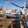 Workers prepare to remove a sailboat washed up onto the edge of the highway into Galveston by Hurricane Ike September 21, 2008 in Galveston, Texas.