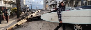 Martina Melendez salvages a surfboard from a flooded bungalow following Superstorm Sandy at Rockaway Beach on November 3, 2012 in the Queens borough of New York City.