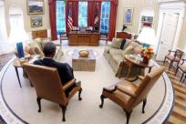 President Barack Obama reads material before the presidential daily briefing in the Oval Office on Aug. 29, 2014. 