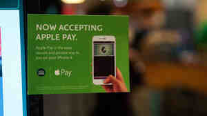 Apple Pay is promoted on signs placed at the cash register of a Whole Foods supermarket in New York.
