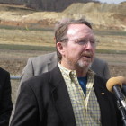 Tom Power, a Montana-based consultant speaks Wednesday at the Auburn Town Hall about the benefits and costs of frac sand mining operations on a town. A Superior Silica sand mine is in the background.