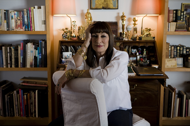 Anjelica Huston sits in her home.